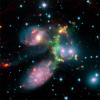 Dieses Falschfarben-Komposit der Zentralregion des Stephans Quintett zeigt ein kompliziertes Geflecht aus Galaxien und intergalaktischem Medium. Das Muster entstand durch die Wechselwirkung der Galaxie NGC7318b (blaue Wolke rechts der Mitte) mit ihrer Umgebung: Das Milchstraßensystem rast mit einer Geschwindigkeit von 1000 Kilometern pro Sekunde in das intergalaktische Medium und erzeugt dadurch eine Schockwelle, die im Licht von Wasserstoffmolekülen grün leuchtet. Das Bild entstand durch die Überlagerung von Aufnahmen, die mit dem Observatorium auf dem Calar Alto in Spanien und dem Weltraumteleskop Spitzer gewonnen wurden.
NASA/JPL-Caltech